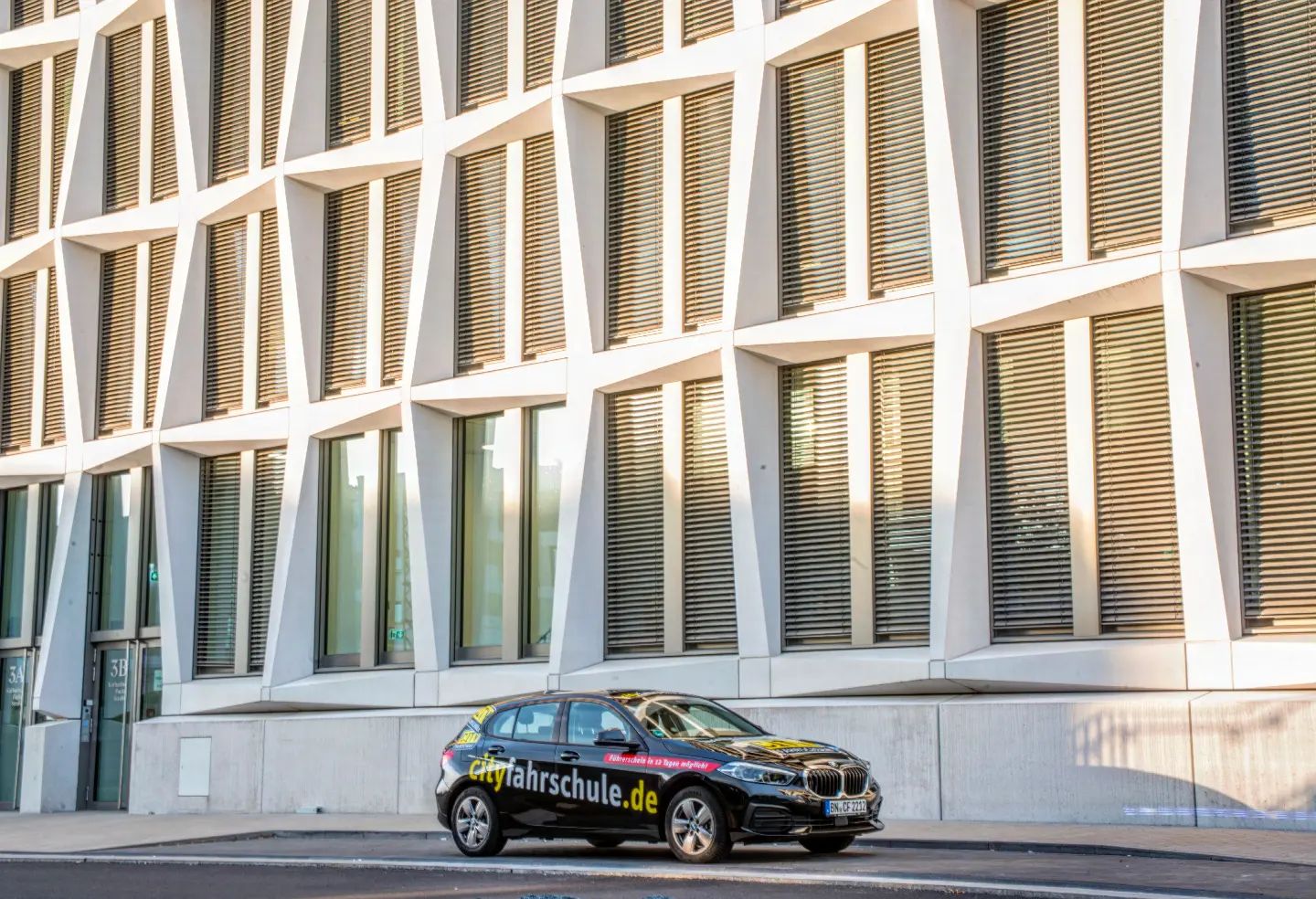 City Fahrschule Auto vor einem Gebäude.