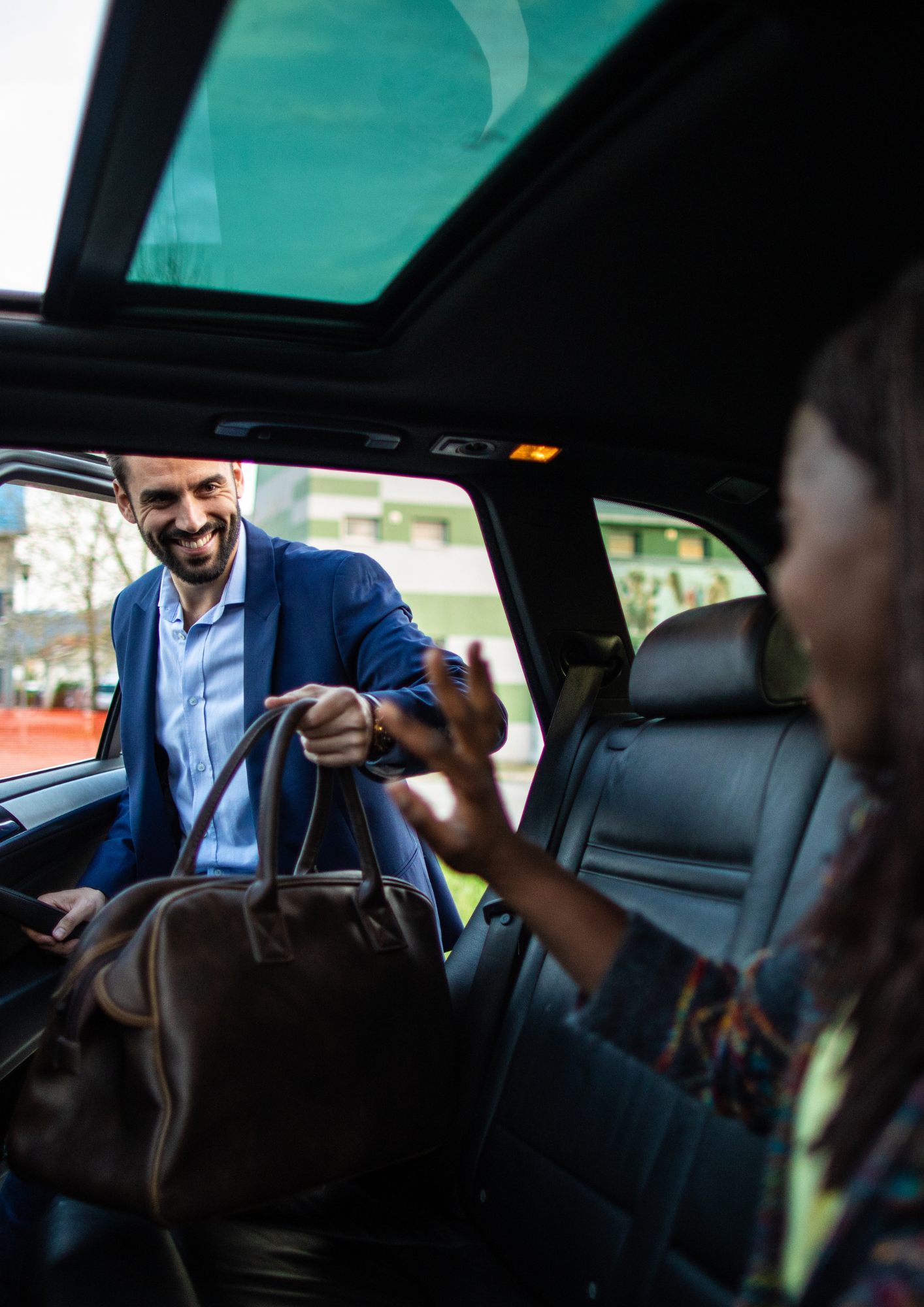 Carsharing. Ein Mann steigt zu einer Frau ins Auto.